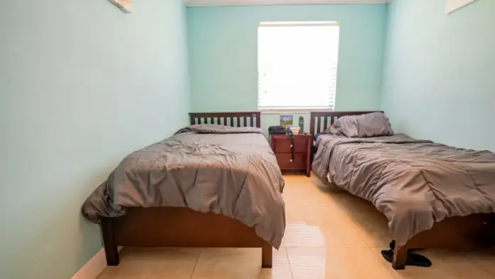 A bedroom at at Reign Residential Treatment Center in Southwest Ranches, FL with 2 comfortable beds